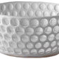 The Lente Acrylic Dinnerware Collection by Mario Luca Giusti features a white bowl with raised circular bumps, ideal for outdoor entertaining and pairing well with blue acrylic pieces.