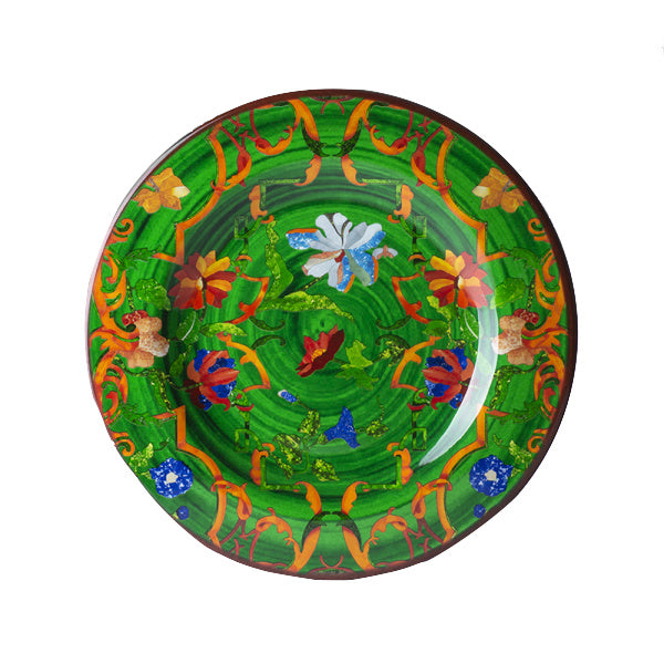The Pancale Green Melamine Dinnerware Collection by Mario Luca Giusti features round plates with a green background, adorned with vibrant floral and abstract patterns, reflecting the brand’s signature modern antique style.