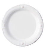 A plain white ceramic plate from Juliska's Berry & Thread French Panel Dinnerware Collection, featuring a slightly raised rim with four decorative knobs, inspired by classic Parisian architecture.