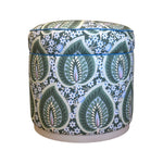 The Grant Swivel Ottoman by Highland House features green, blue, and white botanical leaf and floral upholstery with a smooth 360-degree swivel—an eye-catching accent piece against a white background.