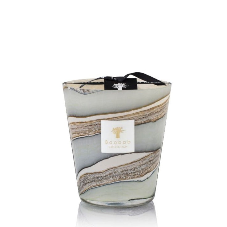Decorative Sand Sonora Candle by Baobab Collection with swirling gray and beige patterns on the glass container, featuring a label, black ribbon, and a hint of patchouli.