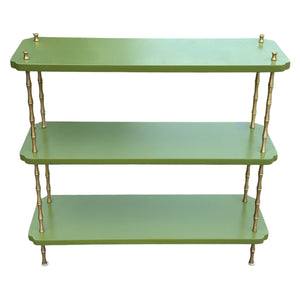 The Satin Lacquered Console Table by Two Worlds Arts Group features green shelves and brass bamboo legs, making it a stylish addition that brings elegance to any minimalist table setting.
