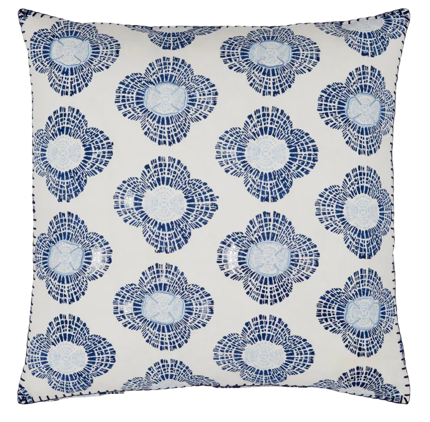 The Nikita Pillow by John Robshaw is a square white accent featuring blue and navy stylized blossoms in a mosaic pattern, with indigo lines evenly spaced across the surface.