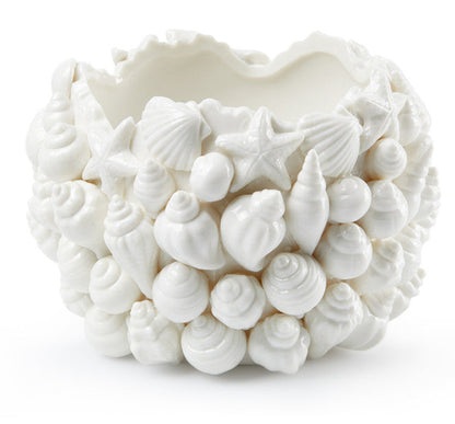 The Sanibel Vase by Villa & House is a white ceramic piece crafted in Blanc de Chine porcelain, featuring an exterior decorated with detailed seashell and starfish designs.