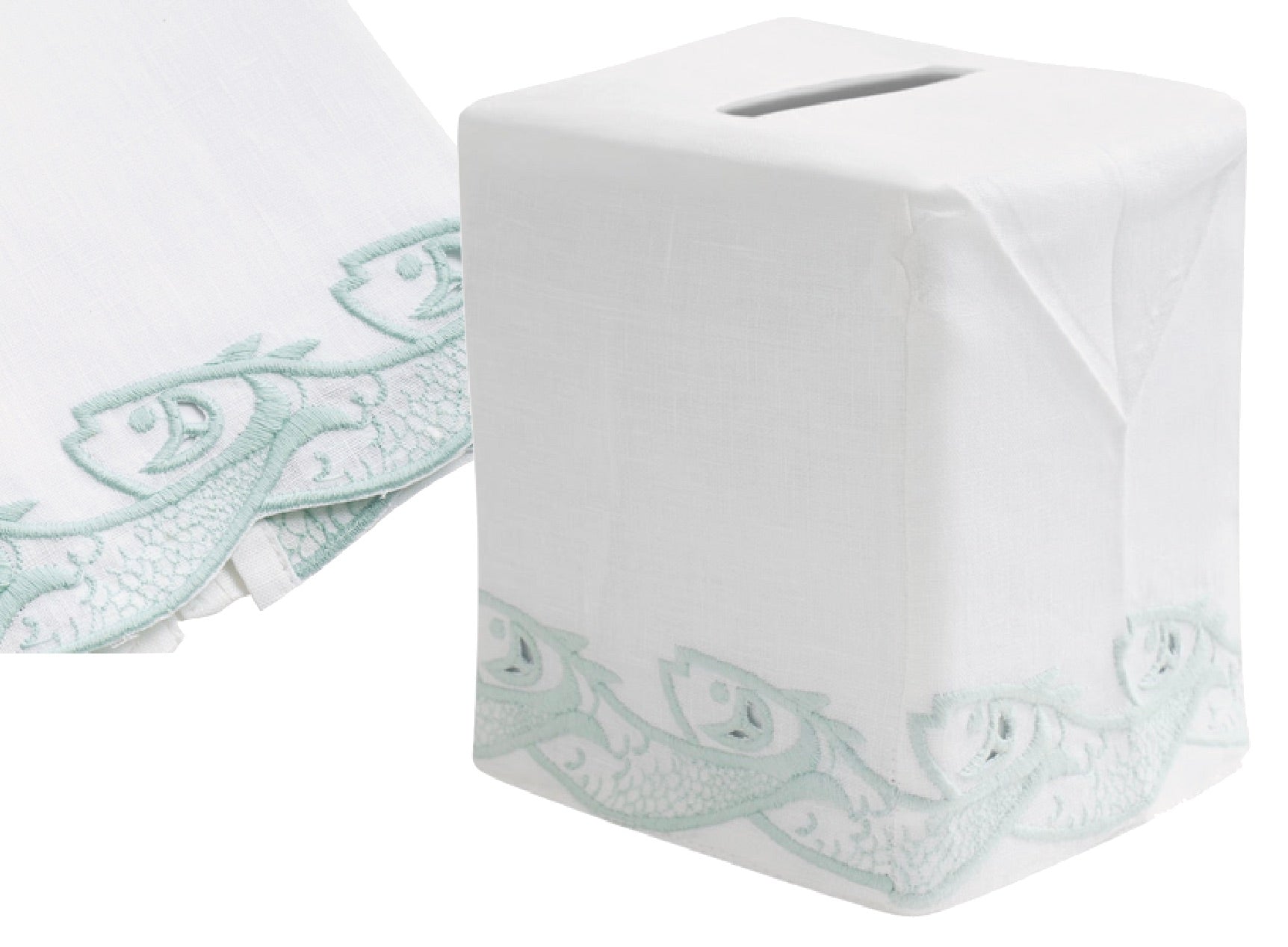The Scrollfish Bath Collection, Aqua by Haute Home includes a white tissue box cover in Italian linen with a hand-embroidered pale blue fish design. The same elegant motif is partially visible on matching fabric beside it.