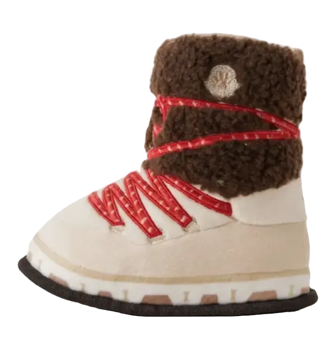 Introducing the Haute Diggity Dog Apres Ski Collection — a plush dog toy inspired by a winter boot, designed in cream and brown with red laces, a soft faux shearling cuff, and a circular logo near the top. Perfect for pups who love ski-themed dog toys or enjoy squeaky fun during playtime!.