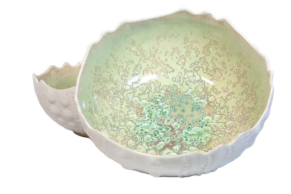 The Sea Urchin Bowl Collection by AE Ceramics includes two hand-molded ceramic bowls with irregular edges and green-beige crystalline glaze—nesting together as unique tabletop accessories or coastal dinnerware.