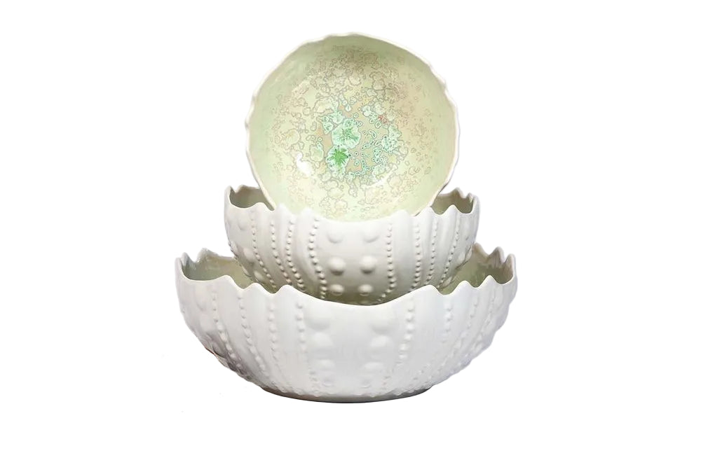 The Sea Urchin Bowl Collection by AE Ceramics features three white hand-molded ceramic bowls with textured exteriors and pale green patterned interiors—an eye-catching addition to coastal dinnerware and unique tabletop accessories.