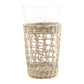 The Be Home Seagrass Cage Glassware Collection features clear glass tumblers partially wrapped in removable seagrass, blending natural style with modern design.