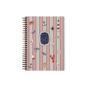 The Seaside Spiral Notebook by Rifle Paper Co. features a cover adorned with vertical pink stripes and nautical-themed illustrations—including anchors, buoys, lobsters, and seashells—expertly printed on heavy-weight textured paper for a premium feel.