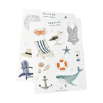 Introducing the Sticker Sheet Sets by Emily Lex Studio—two vibrant vinyl sheets featuring seaside-themed illustrations such as a whale, seagull, swimsuit, chair, crab, shells, anchor, hat, lifebuoy, and beverage carton. Perfect for bringing an ocean-inspired charm to your planner or journals!.