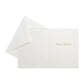 The Caspari Magnolia Bloom Boxed Card Set features elegant white cards with gold "Season's Greetings" text and matching envelopes—ideal for Christmas or holiday cards.