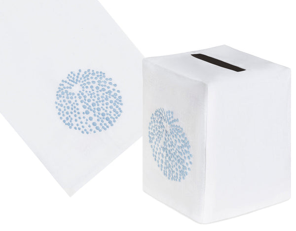 The Sea Urchin Bath Collection by Haute Home features a white Italian linen tissue box cover and towel, each exquisitely hand-embroidered with a light blue dot pattern.