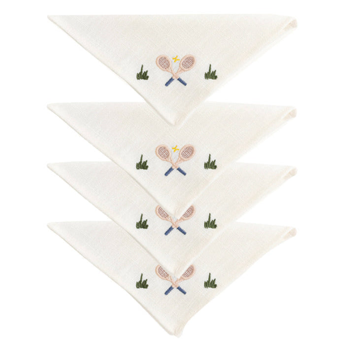 The Duggan Society Cocktail Napkin Collection features four white cotton napkins, each hand-embroidered with crossed tennis rackets, a ball, and green grass accents.