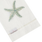 White cloth napkin from the Haute Home Starfish Coaster & Bath Collection, crafted from premium linen with a blue beaded starfish motif and a decorative stitched border, elegantly displayed at an angle—a stylish enhancement to your home décor.