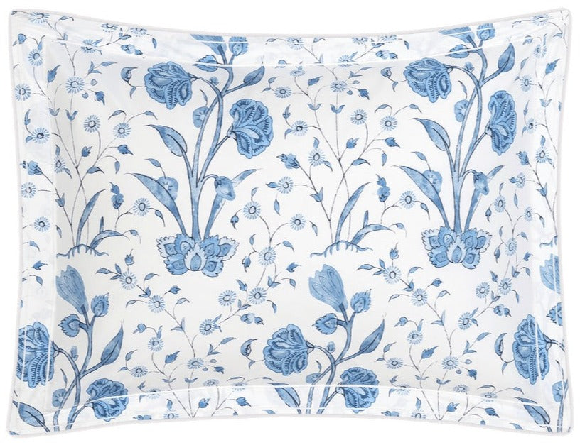 The Schumacher Khilana Bedding Collection, Azure by Matouk features a rectangular pillowcase made from OEKO-TEX certified Egyptian cotton with a white ground and blue floral print of large flowers and small leaves.