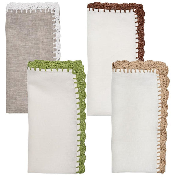 Four folded cloth napkins from Kim Seybert's Shell Edge collection, exuding rustic charm with different colored crocheted edges: one gray with white trim, one white with brown trim, one white with green trim, and one white with beige trim.