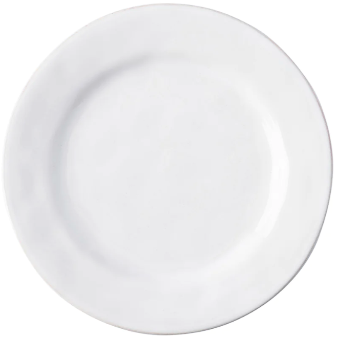 The Juliska Puro Whitewash Dinnerware Collection features a round, white ceramic plate photographed from above on a white background, offering a neutral palette ideal for serving teatime treats or savory tapas.