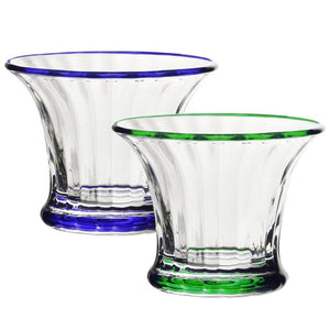 The Siena Mini Vase/Sorbet Dish Collection by William Yeoward Crystal includes two clear glass pieces with classic fluted design and vertical grooves, each featuring colored accents—one blue, one green—on the rim and base.
