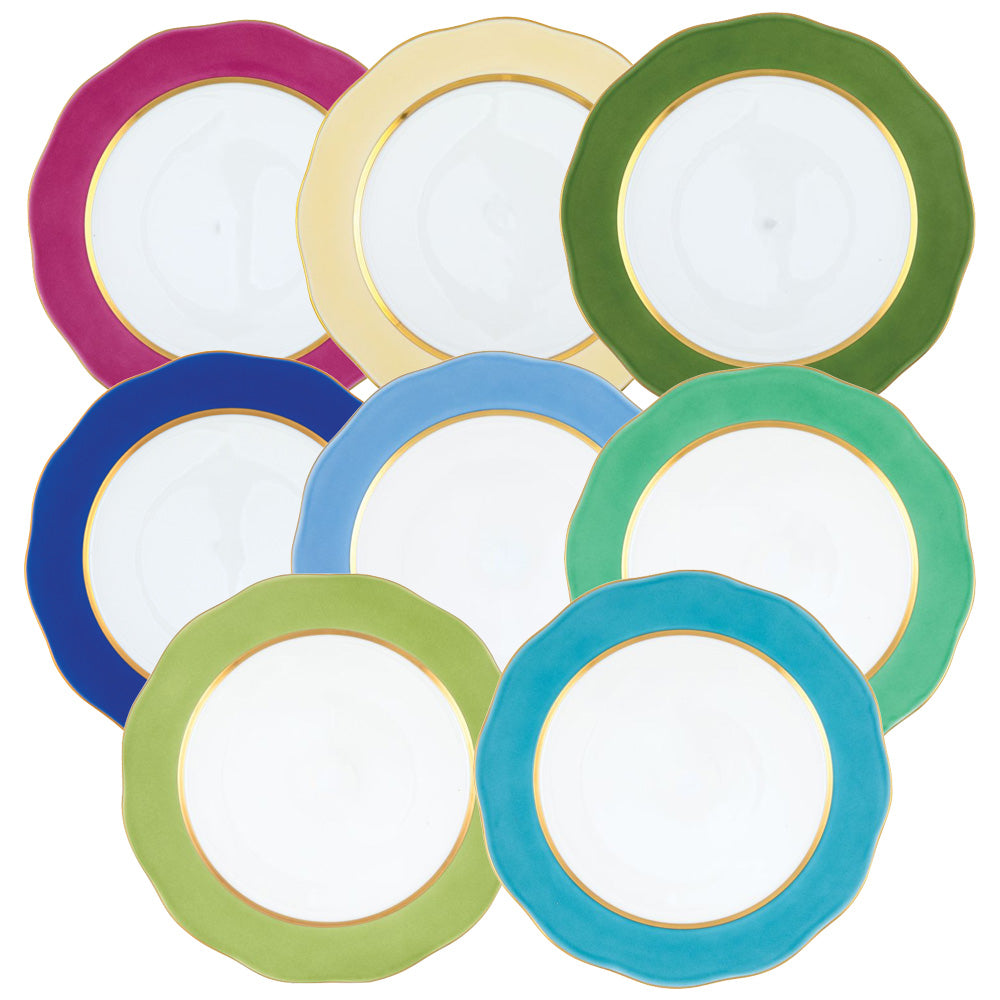 Eight Herend Silk Ribbons Charger plates with scalloped edges, each rimmed in a different color, are arranged in an overlapping pattern for a vibrant, handmade porcelain tabletop display.