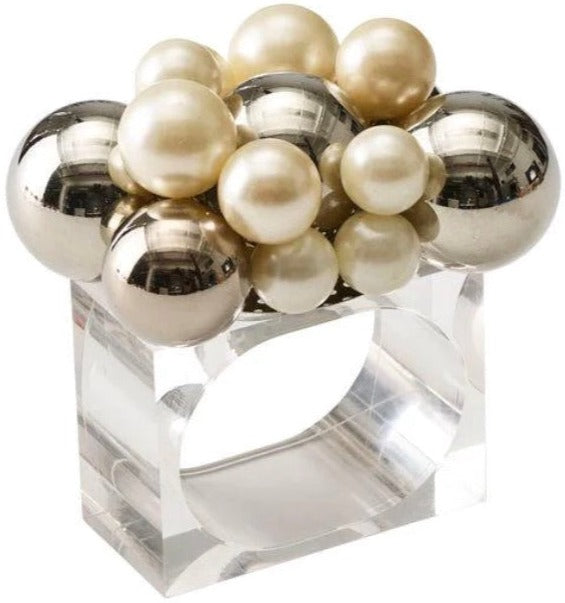 The Kim Seybert Bauble Napkin Ring features a clear lucite rectangular base, topped with shiny silver and cream pearl-like spheres, adding an elegant accent to your table.