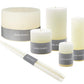 The Ivory Candle Collection by Simon Pearce features artisan candles in assorted shapes and sizes, each with a gray "Simon Pearce" label, adding small-batch elegance to any home.