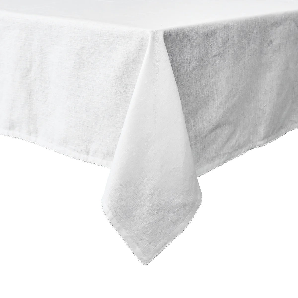 The Juliska Berry Scallop Tablecloth, in white linen and crafted in Portugal, features an elegant scallop trim and drapes gracefully over the corner of a rectangular table against a plain background.