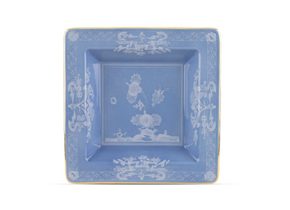 Square blue ceramic plate from the Oriente Italiano Pervinca Serveware & Decor Collection by Ginori 1735, featuring white floral patterns, a gold rim, and raised inner border, photographed on a white background.