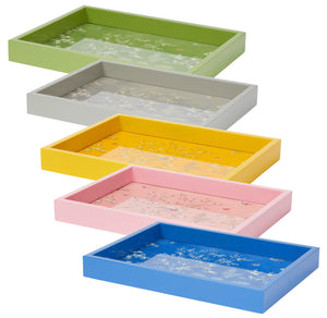 The Addison Ross Small Chinoiserie Tray Collection features five small rectangular trays in green, gray, yellow, pink, and blue with glossy lacquer finishes and delicate floral patterns, arranged in a staggered vertical display.