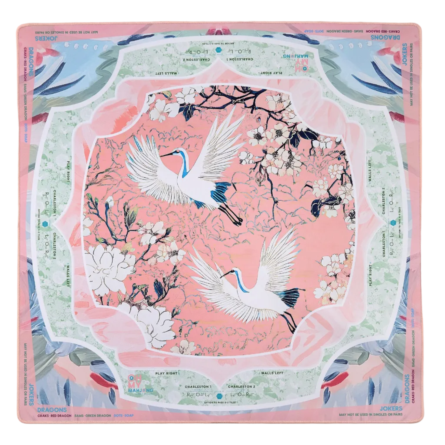 The Oh My Mahjong "Mahjong Mat Collection" features a square silk scarf with two white cranes amid blooming branches on a pink background, accented by pastel green, blue, and light red borders inspired by a Mahjong mat’s elegance.