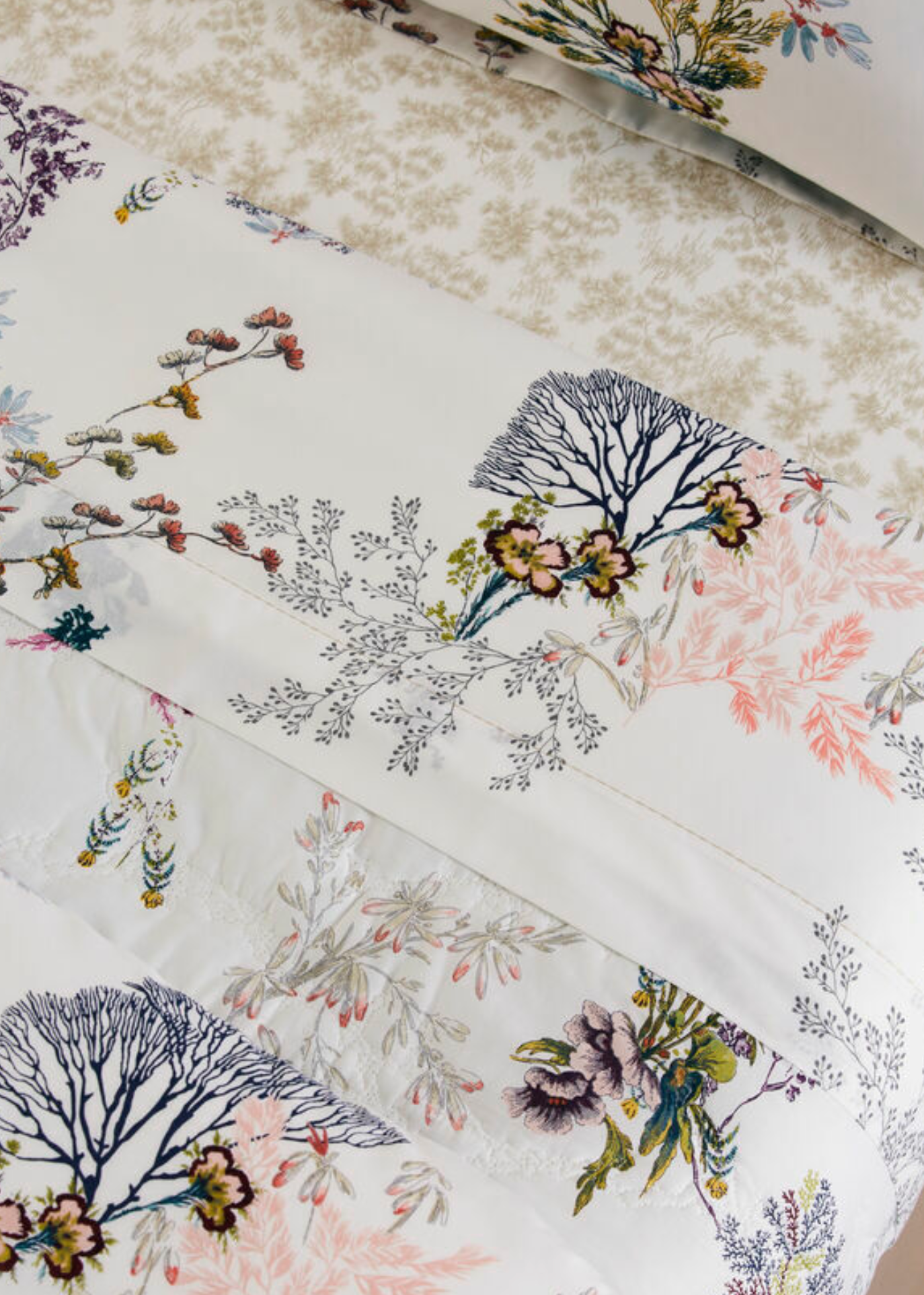 The Naiades Bedding Collection by Yves Delorme showcases bed linens in vibrant floral and botanical prints on white organic cotton, including a reversible duvet cover.