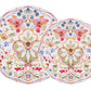 The Sofia Melamine Dinnerware Collection by Juliska features two round plates with intricate, colorful floral patterns on white, adding garden-inspired charm and symmetrical designs to your outdoor gatherings.