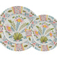Two ceramic plates from the Duggan Society Sorrento Dinnerware Collection feature matching floral patterns in pink, yellow, and green with central bouquets and geometric borders inspired by classic Italian Sorrento designs.