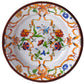 The Pancale White Melamine Dinnerware Collection by Mario Luca Giusti features round plates with a white background, colorful floral and butterfly patterns, and orange, green, and blue decorative borders.