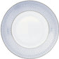 The Tresor Blue Dinnerware Collection by Raynaud features a white porcelain plate with a hand-painted blue honeycomb pattern around the rim, highlighting elegant craftsmanship.