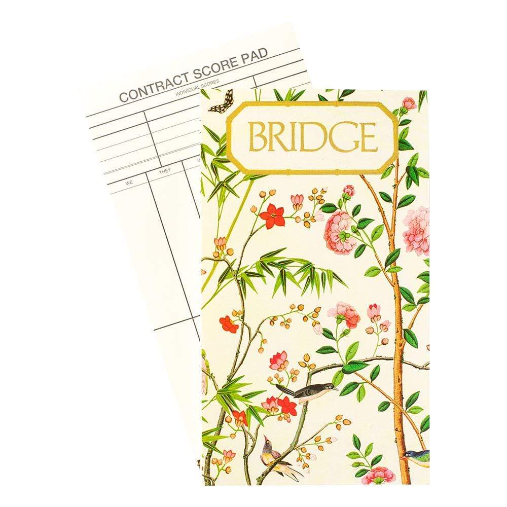 The Caspari Chinese Wallpaper Bridge Collection score pad, featuring elegant floral patterns, partially covers a contract score sheet on a white background—ideal for your next social card game.