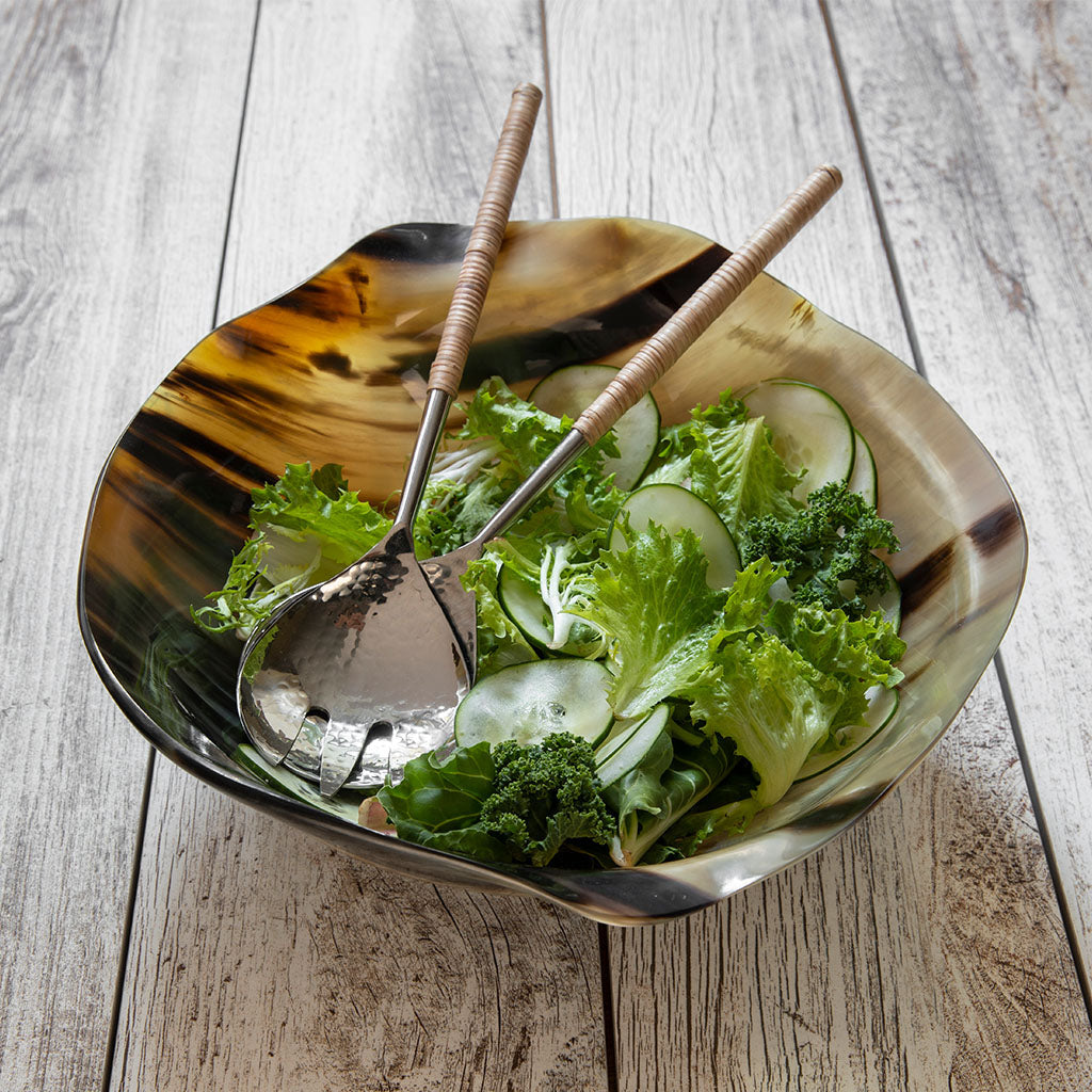 A vibrant green salad with lettuce, kale, and cucumber is beautifully served using Be Home’s Aquila Serving Collection on a rustic wooden surface.