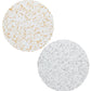 Two round plates—one with gold, one with silver specks—rest on white, evoking celestial elegance inspired by the Kim Seybert Stardust Placemat Collection.