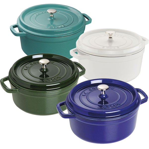 Four round Dutch ovens from the Staub Cast Iron Dutch Oven Collection are displayed, each with a lid. They come in green, white, dark green, and blue colors, featuring stylish metal knobs on top of the lids.