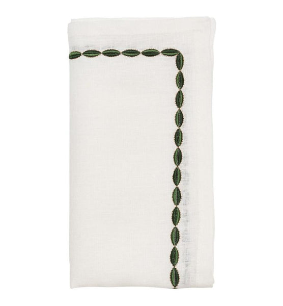 The Kim Seybert Swag Napkin Set, featuring white linen with a green leaf embroidery along two edges, is an elegant addition to any table setting. Perfect for holidays, it brings subtle charm and sophistication to celebrations.