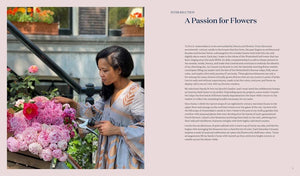 A woman in a patterned dress skillfully arranges pink flowers in a large basket on a city street, holding garden shears as she creates beautiful floral displays. On the right, text introduces “A Sweet Floral Life” from Penguin Random House.