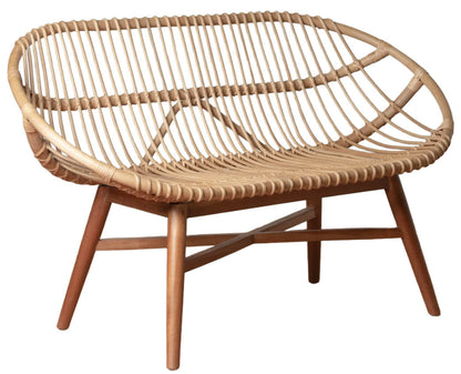 The Emile Rattan Bench by Selamat features a rounded back and seat, crafted from natural rattan with four wooden legs and crossbars for organic charm.