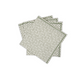 A set of four Laksha napkins by Matouk, stacked slightly askew, each showcasing a green geometric pattern on crisp white in the signature Schumacher style.