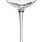 A clear, empty Corinne Collection coupe glass by William Yeoward Crystal—with a wide shallow bowl, thin stem, and round base—features an elegant Jazz Age pattern against a plain white background.