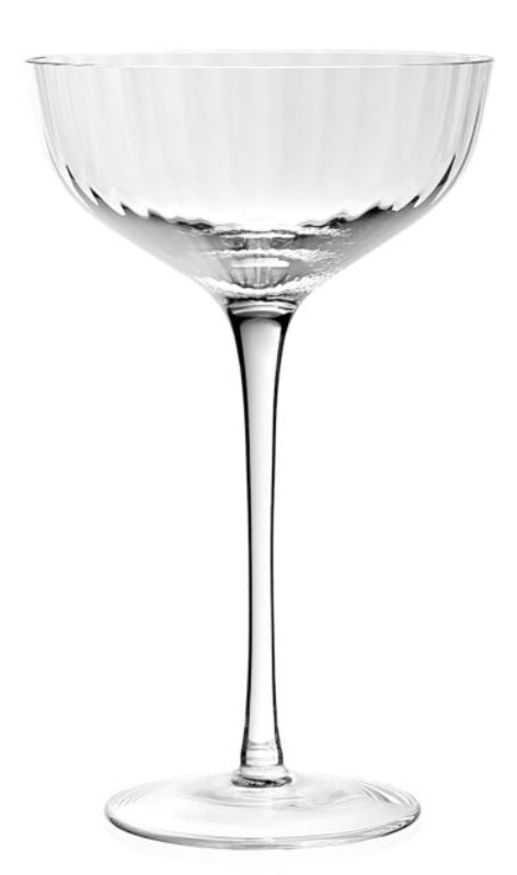 A clear, empty Corinne Collection coupe glass by William Yeoward Crystal—with a wide shallow bowl, thin stem, and round base—features an elegant Jazz Age pattern against a plain white background.
