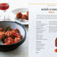 A bowl of meatballs in tomato sauce with bay leaves—a classic among Spanish appetizers—takes center stage, while a glass of red wine sits in the background and an open page from *Tapas* by Simon & Schuster showcases one of the beloved recipes for meatballs in tomato sauce.