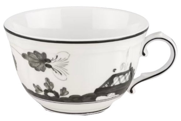 The Oriente Italiano Albus Dinnerware Collection teacup by Ginori 1735 is made of fine white porcelain, adorned with a black floral and geometric pattern, a curved handle, and accented with a thin black line at the rim.