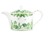 The Cobblers Cove Calypso Dinnerware Collection by Royal Crown Derby features a white ceramic teapot with a round lid and green leaf and vine motifs, evoking a Caribbean feel and pairing perfectly with vibrant green tableware.