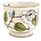 The Pansy Round Cachepot by Anna Weatherley is a white Hungarian porcelain bowl with gold trim, hand painted with green leaves and purple-blue flowers on a vine—ideal as a planter or decorative accent.