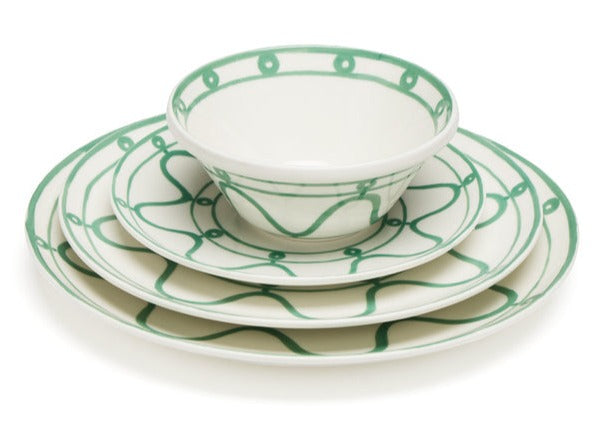 A stack of ceramic dishes from the Themis Z Serenity Green Collection, featuring organic hues and green decorative patterns, including two plates and a bowl.